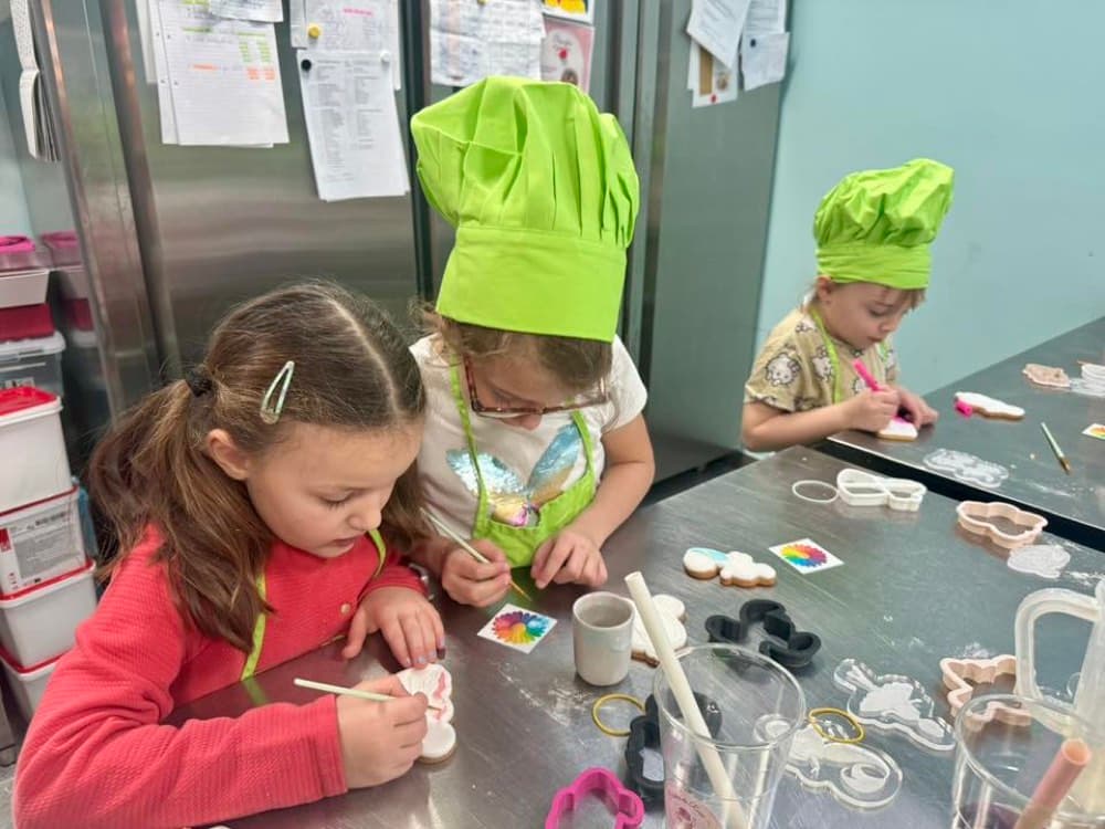Enfants décorant des biscuits en cuisine